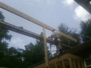 Carpenter setting a ridge beam over a new addition frame — Ice Dam Removal by Roofing Brothers in Stanfordville