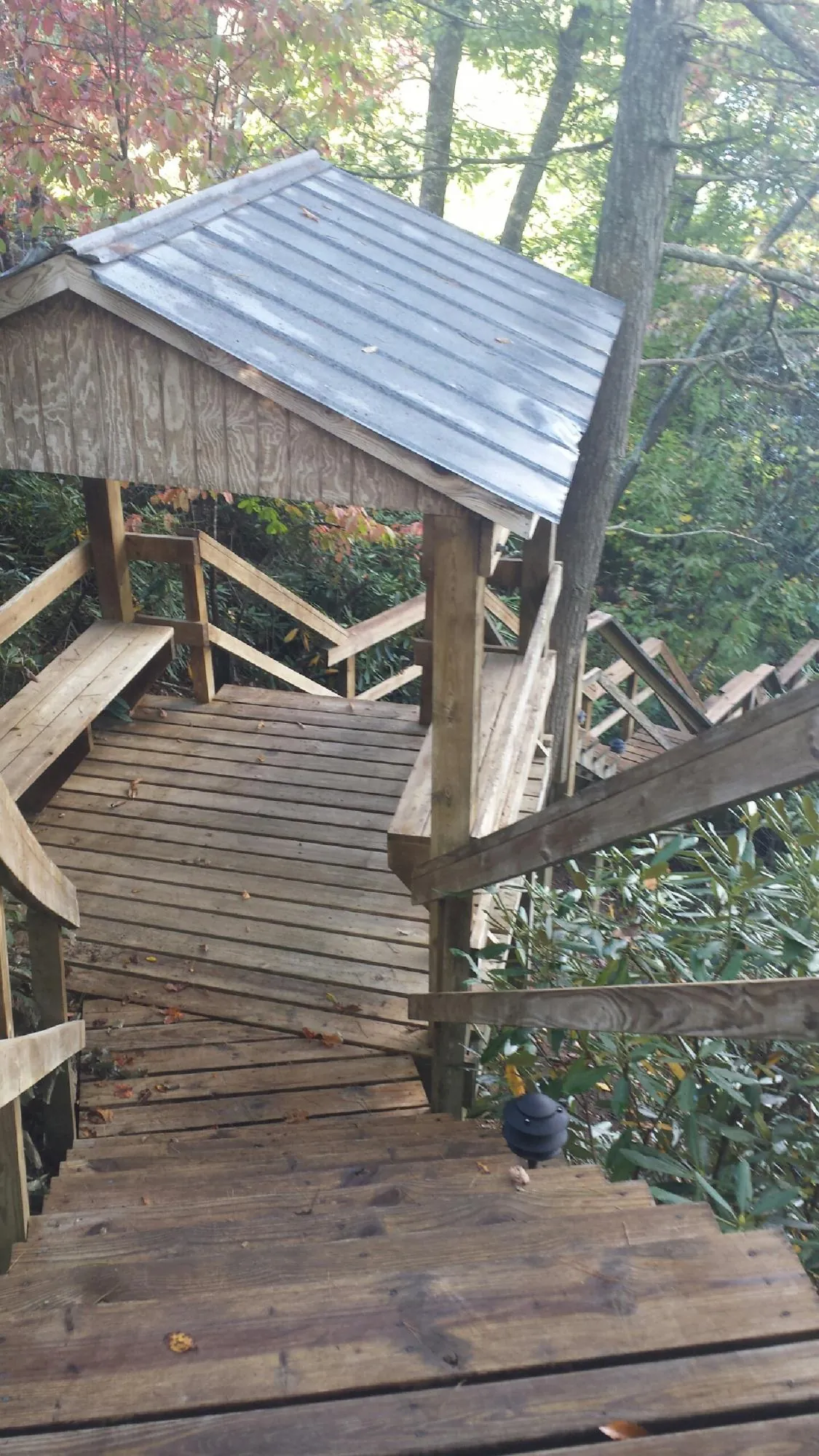 Metal roofed shelter over wooden steps on a wooded walkway — Skylight Repair & Installation work by our crew in Stanfordville